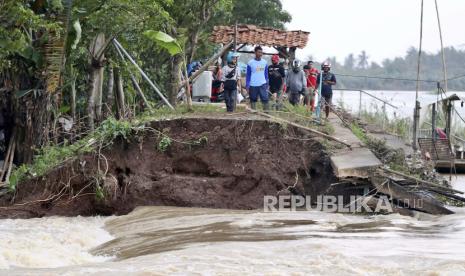  Warga memeriksa lokasi jebolnya tanggul Sungai Citarum yang menyebabkan banjir parah, di Bekasi, Indonesia, Senin, 22 Februari 2021. Ribuan warga dievakuasi di pinggiran ibu kota Indonesia di tengah banjir, kata pejabat Senin.