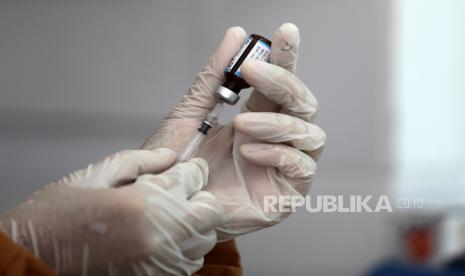  Seorang perawat yang memakai alat pelindung medis mempersiapkan vaksin imunisasi untuk anak-anak selama program vaksinasi door to door terhadap polio, campak dan rubella di tengah pandemi COVID-19 di Banda Aceh, Rabu (7/8/2020). 