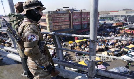 Seorang pejuang Taliban berdiri di jembatan yang menghadap ke pasar luar ruangan, di Kabul, Afghanistan, Senin, 7 Februari 2022.