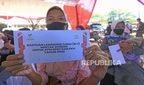 Warga menunjukkan Bantuan Langsung Tunai (BLT) subsidi minyak goreng, ilustrasi