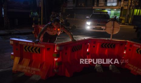 Petugas Kepolisian menyingkirkan pembatas untuk membuka ruas jalan Kawasan Naripan, Bandung, Jawa Barat, Senin (1/6/2020). Satuan Lalu Lintas Polrestabes Bandung kembali membuka 19 titik ruas jalan protokol yang semula ditutup dan disekat saat masa pandemi COVID-19 seiring dengan aturan PSBB Proporsional yang diterapkan oleh Pemerintah Kota Bandung