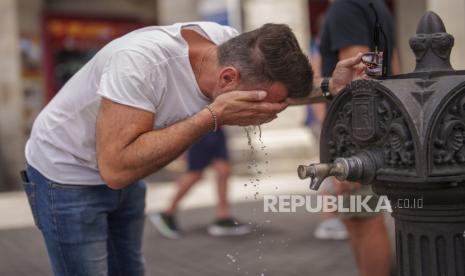 Seorang warga mendinginkan diri dengan air saat cuaca panas di Madrid, Spanyol, Rabu (19/7/2023). 