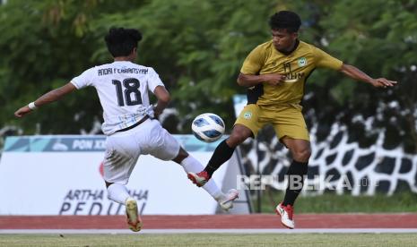 Pesepak bola Maluku Utara Abjan Idris (kanan) berebut boia dengan pesepak bola Jawa Barat Andri Febriansyah (kiri) saat pertandingan penyisihan sepak bola putra PON Papua di Stadion Mahacandra Universitas Cendrawasih, Kota Jayapura, Papua, Ahad (3/10/2021). Tim Jawa Barat taklukan tim Maluku Utara dengan skor akhir 3-1. 