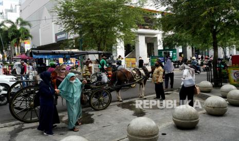 Wisatawan usai berkeliling dengan andong di kawasan wisata Malioboro, Yogyakarta, Selasa (2/11). Pemkot Yogyakarta melakukan pembatasan durasi kunjung di objek wisata Malioboro. Wisatawan yang berkunjung diimbau untuk membatasi durasi selama dua jam dan parkir selama tiga jam. Hal ini dilakukan untuk mengontrol jumlah pengunjung di Malioboro. Malioboro masih menjadi favorit kunjungan wisatawan saat senja hingga malam.