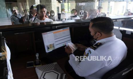 Seorang petugas Imigrasi memeriksa paspor Pekerja Migran Indonesia (PMI) menjelang diberangkatkan ke Malaysia melalui Pos Lintas Batas Negara (PLBN) Terpadu Aruk di Kabupaten Sambas, Kalimantan Barat, Selasa (18/10/2022). (Ilustrasi)