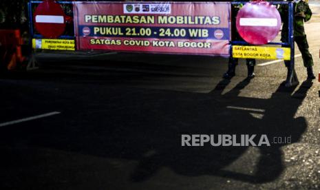 Bayangan petugas saat penutupan ruas Jalan Jenderal Sudirman, Kota Bogor, Jawa Barat, Senin (5/5) malam. penutupan tersebut dilakukan untuk membatasi mobilitas warga di malam hari pada masa Pemberlakukan Pembatasan Kegiatan Masyarakat (PPKM) Darurat untuk mengurangi penyebaran virus Covid-19. Republika/Putra M. Akbar