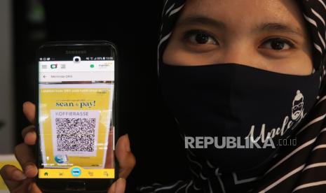 Pengunjung tengah bertransaksi dengan metode pembayaran digital QRIS. ilustrasi