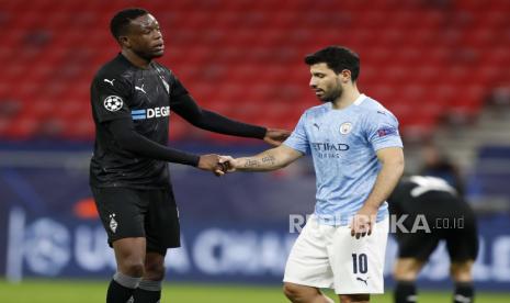 Denis Zakaria dari Moenchengladbach, kiri, dan Sergio Aguero dari Manchester City berjabat tangan setelah pertandingan leg kedua babak 16 besar Liga Champions antara Manchester City dan Borussia Moenchengladbach di Puskas Arena di Budapest, Hongaria, Selasa, 16 Maret 2021. 