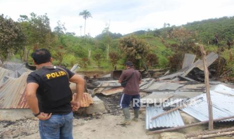 Polisi memeriksa bangunan yang dibakar dalam serangan yang diduga dilakukan kelompok teroris Mujahidin Indonesia Timur (MIT) pimpinan Ali Kalora di Dusun Lewonu, Desa Lemban Tongoa, Kecamatan Palolo, Kabupaten Sigi, Sulawesi Tengah, Sabtu (28/11/2020).   