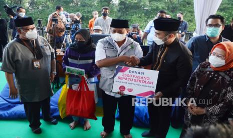 Wakil Gubernur Jawa Barat Uu Ruzhanul Ulum (tengah) secara simbolis menerima donasi sepatu untuk anak yatim piatu di Provinsi Jawa Barat saat Kick Off Perlindungan dan Pemberdayaan Anak Yatim, Piatu dan Yatim Piatu Terdampak Covid-19 di Plaza Gedung Sate, Kota Bandung, Selasa (28/9). Kegiatan tersebut merupakan wujud kepedulian Pemprov Jawa Jawa Barat terhadap anak yatim piatu khususnya yang ditinggal orang tuannya akibat wabah Covid-19.