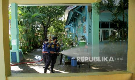 Petugas pemadam kebakaran menyemprotkan cairan disinfektasn di Sekolah Negeri Percontohan PAM di Makassar, Sulawesi Selatan, Kamis (17/6/2021). Pemerintah Kota Makassar melakukan sterilisasil di semua sekolah dengan menyemprotkan cairan disinfektan guna mengantisipasi penularan COVID-19 jelang pembelajaran tatap muka terbatas di daerah itu. 