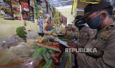 Polisi memantau harga sembako di Pasar Nambangan Surabaya, Jawa Timur, Selasa (7/4/2020). Operasi pasar yang dilakukan pihak kepolisian setempat itu untuk memantau harga sekaligus ketersediaan sembilan bahan pokok (sembako) yang dijual di pasaran