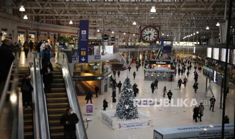 Orang-orang melewati jam sibuk pagi hari di stasiun kereta Waterloo di London, Selasa, 14 Desember 2021. Mulai Senin di Inggris, orang-orang didesak untuk bekerja dari rumah jika memungkinkan, dengan antrean panjang di pusat vaksinasi bagi orang-orang untuk dapatkan suntikan booster untuk melindungi diri mereka dari varian virus corona omicron.