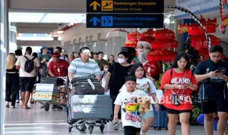 Calon penumpang pesawat membawa barang bawaan di Terminal Domestik Bandara Internasional I Gusti Ngurah Rai, Badung, Bali, Selasa (2/1/2024). Pengelola Bandara Bali memprediksi akan melayani sebanyak 69.436 orang penumpang penerbangan rute domestik dan internasional saat puncak arus balik liburan tahun baru pada Selasa (2/1). 