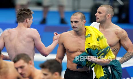 Duncan Scott dari Inggris (kiri) berjabat tangan dengan Zac Incerti dan Kyle Chalmers dari Australia setelah Final Estafet Gaya Bebas 4 x 200m Putra di Tokyo Aquatics Center saat Olimpiade 2020 di Tokyo, Jepang, 28 Juli 2021. Bulatan bekas bekam tampak di tubuh Kyle Chalmers.