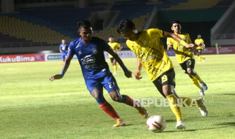 Kapten Arema FC Dedik Setiawan mencoba merebut bola dari bek Barito Rifqy pada pertandingan penyisihan grup A Piala Menpora 2021 di Stadion Manahan, Solo, Jawa Tengah, Kamis (25/3) malam. Pada pertandingan ini Barito Putera berhasil mengalahkan Arema FC 2-1.