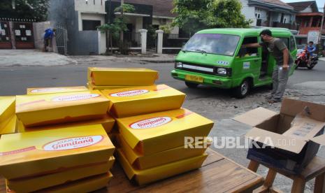 Relawan membagikan paket nasi dan ayam untuk sopir angkutan kota (angkot) saat aksi Berbagi Paket Jumat Berkah di jalan Kebon Pedes, Kota Bogor, Jawa Barat, Jumat (3/4/2020). Pembagian paket makanan tersebut untuk membantu meringankan ekonomi mereka di saat wabah pandemi virus Corona (COVID-19) yang menyebabkan menurunnya jumlah penumpang