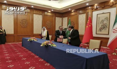 Dalam foto yang dirilis oleh Nournews ini, Sekretaris Dewan Keamanan Nasional Tertinggi Iran, Ali Shamkhani, kanan, berjabat tangan dengan diplomat paling senior China Wang Yi, saat Penasihat Keamanan Nasional Arab Saudi Musaad bin Mohammed al-Aiban terlihat saat upacara penandatanganan perjanjian antara Iran dan Arab Saudi untuk membangun kembali hubungan diplomatik dan membuka kembali kedutaan setelah tujuh tahun ketegangan antara rival Timur Tengah, di Beijing, China, Jumat (10/3/2023). 