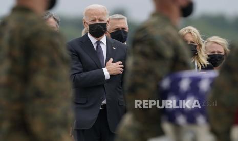 Presiden Joe Biden dan ibu negara Jill Biden menyaksikan tim pembawa memindahkan peti transfer yang berisi sisa-sisa Kopral Korps Marinir. Humberto A. Sanchez, 22, dari Logansport, Ind., selama pengembalian korban Minggu, 29 Agustus 2021, di Pangkalan Angkatan Udara Dover, Del.