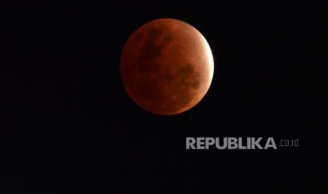  Bulan terlihat saat bayangan bumi menutupi bulan saat gerhana bulan sebagian di Brisbane, Australia, 19 November 2021. Gerhana pertama pada 2022 terjadi 30 April/1 Mei yakni gerhana matahari sebagian.