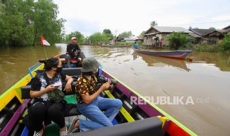 Wisatawan menikmati pemandangan saat wisata susur sungai di Hutan Mangrove Alami Kuin Kecil, Banjarmasin, Kalimantan Selatan. Pemprov Kalimantan Selatan terus berupaya meningkatkan kunjungan pariwisata, salah satunya wisata susur sungai di Banjarmasin yang menawarkan suasana alam serta aktivitas warga di bantaran sungai untuk menggaet para wisatawan baik dari dalam negeri maupun luar negeri.