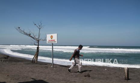 Pengunjung berada di kawasan Pantai Depok, Bantul, DI Yogyakarta, Selasa (26/7/2022). Badan Meteorologi, Klimatologi dan Geofisika (BMKG) mengeluarkan peringatan dini terjadinya peningkatan gelombang air laut di pantai selatan Jawa.