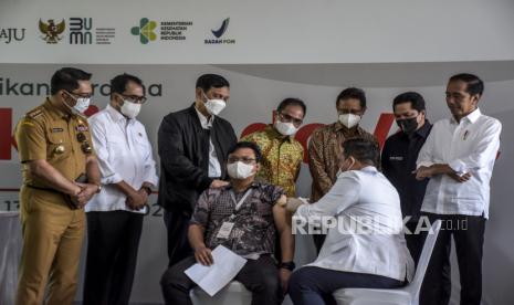 Presiden Joko Widodo (kanan) bersama Menteri BUMN Erick Thohir (kedua kanan), Menko Marves Luhut Binsar Pandjaitan (ketiga kiri), Direkur Utama PT Bio Farma Honesti Basyir (tengah), Menteri Kesehatan Budi Gunadi Sadikin (ketiga kanan), Menteri Perhubungan Budi Karya Sumadi (kedua kiri) dan Gubernur Jawa Barat Ridwan Kamil (kiri) menyaksikan penyuntikan Vaksin IndoVac usai diluncurkan di PT Bio Farma (Persero), Jalan Pasteur, Kota Bandung, Kamis (13/10/2022). Presiden Joko Widodo secara resmi meluncurkan vaksin Covid-19 bernama IndoVac yang diproduksi oleh PT Bio Farma (Persero). Vaksin IndoVac tersebut mulai diproduksi secara massal pada Kamis (13/10/2022) dengan target mencapai 20 juta dosis dan akan meningkat 40 juta dosis pada tahun 2023. Republika/Abdan Syakura