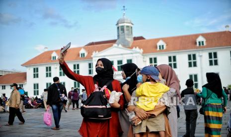 Pengunjung berswafoto area Museum Fatahillah kawasan Kota Tua, Jakarta, Kamis (5/5/2022). Dinas Bina Marga DKI Jakarta terus mengejar target penyelesaian revitalisasi trotoar di kawasan Kota Tua, Jakarta Barat yang diharapkan selesai pada Juli ini.