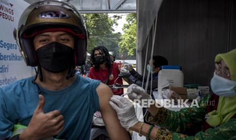 Vaksinator menyuntikkan vaksin Covid-19 ke warga saat pelaksanaan vaksinasi menggunakan sistem layanan tanpa turun (lantatur) di Taman Tegallega, Kota Bandung, Selasa (9/11).