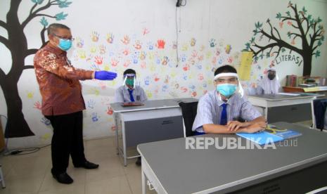 Gubernur Kalimantan Barat Sutarmidji (kiri) memberikan instruksi tentang jaga jarak antar kursi saat meninjau kegiatan belajar tatap muka di SMAN 1 Pontianak, Kalbar, Kamis (3/9/2020). Sutarmidji meminta sekolah-sekolah untuk selalu berinovasi dalam penerapan protokol kesehatan guna membuat lingkungan belajar yang aman dan sehat bagi guru serta siswa. 