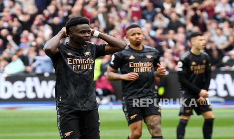 Reaksi pemain Arsenal Bukayo Saka (kiri) setelah melewatkan peluang mencetak gol dari titik penalti pada pertandingan sepak bola Liga Inggris antara West Ham United dan Arsenal London di London, Inggris, Ahad (16/4/2023).