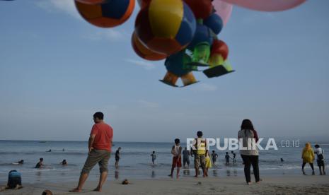 Wisatawan mengunjungi kawasan wisata Pantai Santolo, Pameungpeuk, Kabupaten Garut, Jawa Barat, Minggu (20/9/2020). Pantai Santolo menjadi salah satu destinasi wisata populer di Garut bagian selatan yang memiliki bentang pantai yang cukup panjang dan ramai dikunjungi wisatawan domestik maupun mancanegara. ANTARA FOTO/Candra Yanuarsyah/agr/foc.