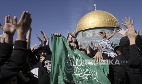 OKI: Israel harus Bertanggung Jawab atas Kejahatan di Palestina. Foto: Warga Palestina memegang bendera Hamas, memprotes Masjid Dome of the Rock di kompleks Masjid Al-Aqsa di Kota Tua Yerusalem, Jumat, 27 Januari 2023. Protes itu sehari setelah serangan paling mematikan Israel dalam beberapa dasawarsa. prospek gejolak besar dalam pertempuran.