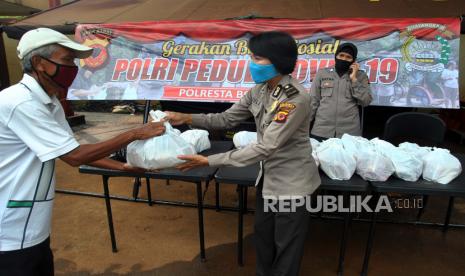 ilustrasi. Anggota Polwan Polresta Bogor Kota menyerahkan bantuan paket sembako kepada warga saat Gerakan Bakti Sosial Polri Peduli COVID-19 di Mako Polresta Bogor Kota, Kapten Muslihat, Kota Bogor, Jawa Barat, Selasa (21/4/2020). Gerakan Bakti Sosial Polri Peduli COVID-19 tersebut dilaksanakan sebagai wujud nyata kepedulian Polri terhadap masyarakat yang terdampak akibat mewabahnya pandemi virus Corona dengan membagikan paket sembako