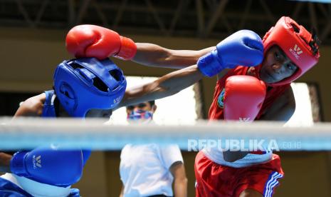 Petinju  putri Papua Hana Kendi (kiri)  memukul petinju putri Papua Barat Merlin Tomatala (kanan) saat bertanding pada babak  penyisihan Tinju Kelas Terbang Ringan Putri 45-48 Kg PON Papua di Gor Cendrawasih, Jayapura, Papua, Selasa (5/10/2021). 