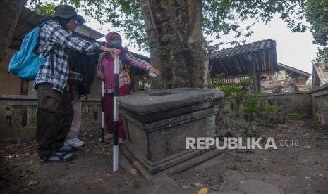 Mahasiswa Arkeologi Universitas Gadjah Mada (UGM) mengukur batu yoni di Kropakan, Mranggen, Jatinom, Klaten, Jawa Tengah, Ahad (20/8/2023). Selain mengumpulkan data berbagai temuan fragmen ODCB dan sumur kuno, kegiatan yang dilakukan oleh Badan Riset dan Inovasi Nasional (BRIN) bersama mahasiswa Arkeologi UGM dan Geografi UGM itu juga mengumpulkan data sampel tanah untuk melengkapi temuan objek diduga cagar budaya pada masa Mataram Kuno. 