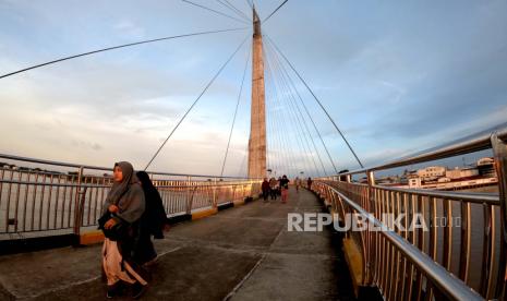 Warga menyeberang di jembatan pedestrian Gentala Arasy di atas Sungai Batanghari, Jambi, Rabu (13/5/2020). Dinas Kebudayaan dan Pariwisata Provinsi Jambi membatalkan hampir semua dari 40 agenda pariwisata sepanjang 2020 yang telah dijadwalkan sebelumnya di provinsi itu akibat pandemi COVID-19