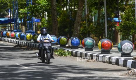 Kendaraan bermotor melintas di trotoar Komplek Olahraga Dadaha, Kota Tasikmalaya, Jawa Barat, Jumat (20/11/2020). Trotoar jalan utama Komplek Olahraga Dadaha dihiasi ornamen bola batu dengan lukisan payung geulis agar tidak terkesan kumuh dan meminimalisir PKL di kawasan tersebut. 