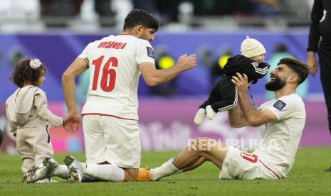 Iran Mahdi Torabi and Iran Ali Gholi Zadeh, right, celebrate with children at the end of the Asian Cup quarterfinal soccer match between Japan and Iran at Education City Stadium in Al Rayyan, Qatar, Saturday, Feb. 3, 2024.