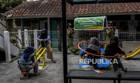 Petugas Linmas memanggul replika keranda mayat saat sosialisasi perpanjangan Pemberlakuan Pembatasan Kegiatan Masyarakat (PPKM) Skala Mikro di Cimahi Tengah, Kota Cimahi, Selasa (23/2). Pemerintah memperpanjang Pemberlakuan Pembatasan Kegiatan Masyarakat (PPKM) Skala Mikro di Jawa dan Bali meliputi 123 kabupaten/kota di tujuh provinsi yakni DKI Jakarta, Banten, Jawa Barat, Jawa Tengah, Jawa Timur, DI Yogyakarta dan Bali mulai 23 Februari hingga 8 Maret guna menekan laju kasus serta mencegah penyebaran Covid-19 di tingkat desa atau kelurahan. Foto: Abdan Syakura/Republika