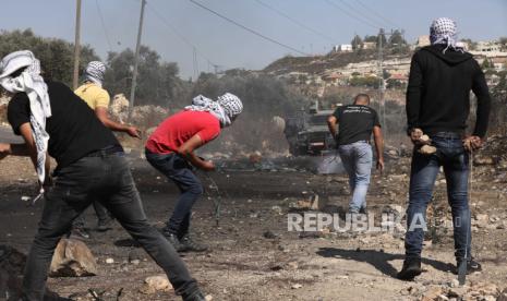  Pengunjuk rasa Palestina melemparkan batu ke pasukan Israel selama bentrokan setelah demonstrasi menentang permukiman Israel di desa Kofr Qadom dekat kota Nablus, Tepi Barat utara, 02 Oktober 2020. Tujuh warga Palestina terluka selama bentrokan itu.