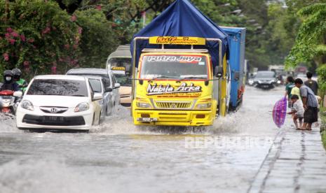 Kendaraan menerobos banjir di Jalan Raya Juanda, Sidoarjo, Jawa Timur, Senin (28/6/2021). Hujan yang turun dengan intensitas cukup tinggi sejak Minggu (27/6)  menyebabkan aktivitas transportasi di kawasan bandara juanda tergenang banjir dengan ketinggian 20-40 cm. 