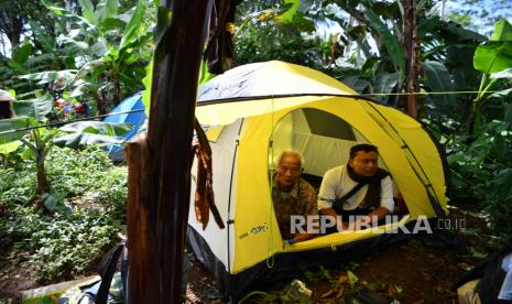 Warga beristirahat di tenda yang dibangun di sekitar rumahnya yang rubuh akibat gempa di Desa Kali Uling, Lumajang, Jawa Timur, Ahad (11/4/2021). Sekitar ratusan rumah warga di wilayah itu rusak akibat gempa bermagnitudo 6,1 SR yang terjadi di Kabupaten Malang pada Sabtu (10/4). 