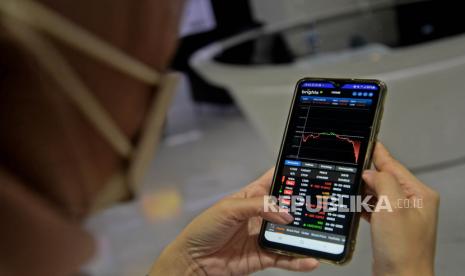 Seorang investor muda melihat pergerakan harga saham melalui ponselnya (ilustrasi). Direktur Anugerah Mega Investama Hans Kwee menilai, para Generasi Z dan milenial sudah seharusnya mendominasi jumlah investor dan transaksi di pasar saham. Sebab perkembangan informasi tentang saham sangat masif di kalangan mereka.