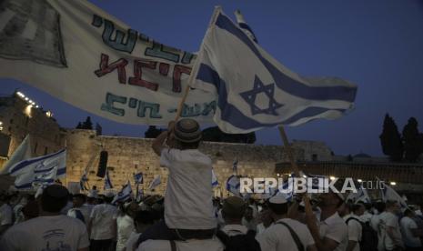 Warga Israel mengibarkan bendera nasional (ilustrasi). Warga Israel menilai perombakan peradilan justru akan merugikan penduduk 