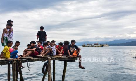 Sejumlah anak-anak duduk bersama di dermaga daerah Pantai Batu Merah, Kota Ambon, Maluku, bertepatan dengan peringatan Hari Anak Nasional, Jumat (23/7/2021). 