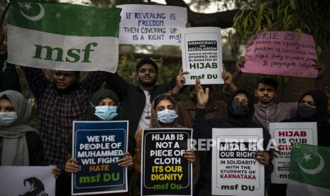  Pelajar Muslim India memegang plakat saat mereka meneriakkan slogan-slogan selama protes menentang pelarangan gadis Muslim mengenakan jilbab menghadiri kelas di beberapa sekolah di negara bagian Karnataka, India selatan, di New Delhi, India, Selasa, 8 Februari 2022. Staf sekolah menengah dan pihak berwenang menuduh gadis-gadis itu menentang aturan seragam tetapi para siswa mengatakan mereka kehilangan hak yang dijamin secara konstitusional untuk mempraktikkan keyakinan mereka.