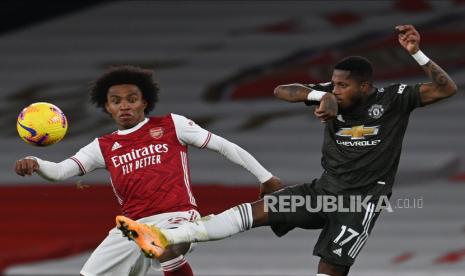  Willian (kiri) dari Arsenal beraksi melawan Fred (kanan) dari Manchester United selama pertandingan sepak bola Liga Utama Inggris antara Arsenal FC dan Manchester United di London, Inggris, Sabtu (30/1).