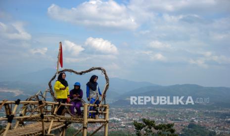 Wisatawan berswafoto dengan latar Kota Sumedang, di Puncak Gunung Pangadegan, Desa Rancamulya, Kabupaten Sumedang, Jawa Barat, Rabu (2/9/2020). Pengurus Desa Rancamulya berinisiatif untuk mengalihfungsikan Puncak Gunung Pangadegan menjadi kawasan wisata foto selfie secara swadaya guna mendongkrak perekonomian warga melalui sektor pariwisata. 