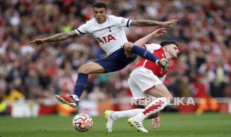 Pedro Porro dari Tottenham berebut bola dengan pemain Arsenal Declan Rice (kanan) saat pertandingan sepak bola Liga Premier Inggris antara Arsenal dan Tottenham Hotspur di stadion Emirates di London, Inggris, Ahad, (24/9/2023).